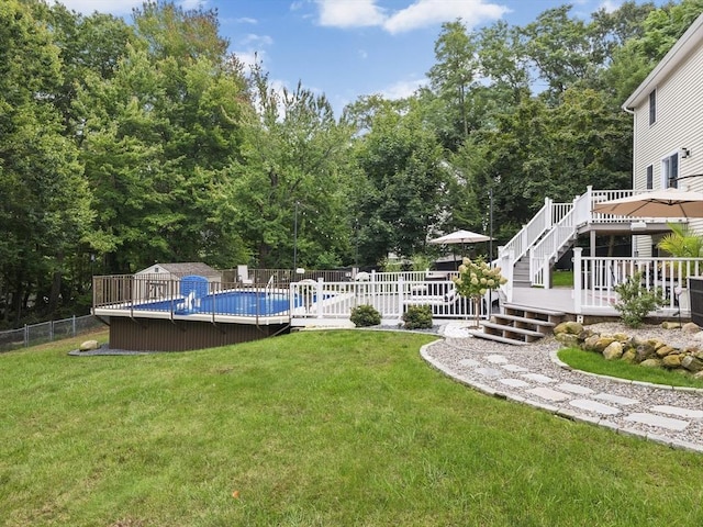 view of yard featuring a deck, fence, and a fenced in pool