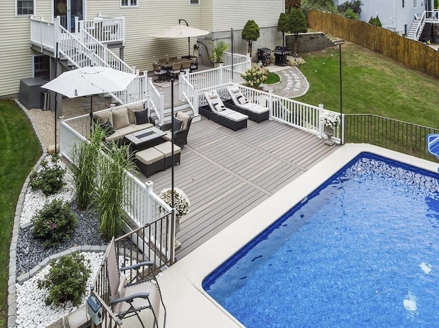 view of pool with fence, a yard, stairs, a deck, and an outdoor hangout area