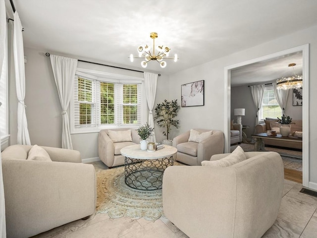 living area featuring a notable chandelier and baseboards