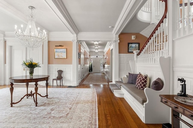 4 Cobb Ave, Manchester, MA 01944 - entryway featuring crown molding, a decorative wall, dark wood-style flooring, a chandelier, and stairs