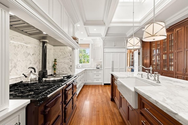 4 Cobb Ave, Manchester, MA 01944 - kitchen with light wood-style floors, glass insert cabinets, brown cabinets, light stone countertops, and recessed lighting