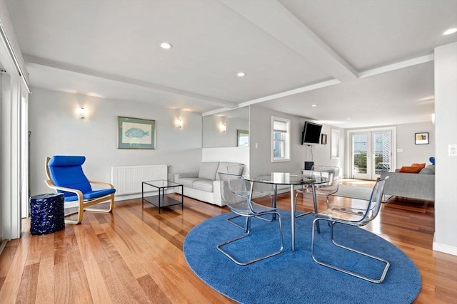 dining space with radiator, wood finished floors, recessed lighting, and beamed ceiling