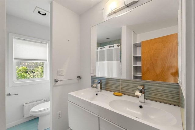 bathroom with radiator, toilet, double vanity, a shower with shower curtain, and baseboards