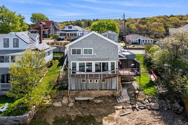 back of property with a deck and stairs