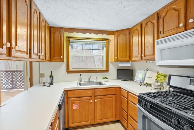 kitchen with sink, a textured ceiling, and appliances with stainless steel finishes