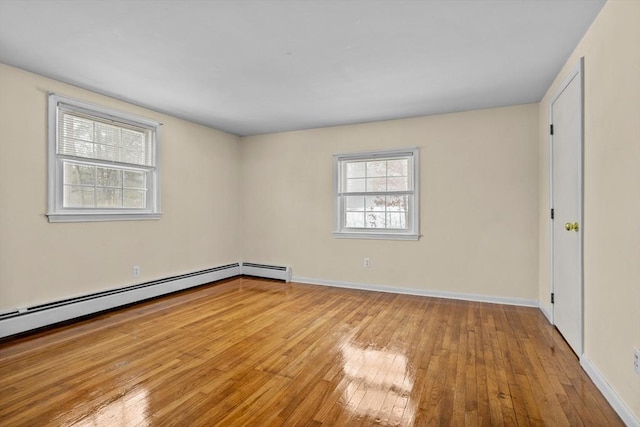 empty room featuring a baseboard radiator and light hardwood / wood-style flooring