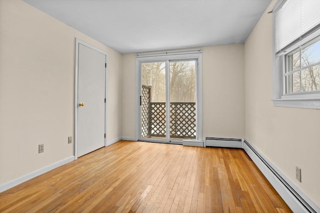 spare room featuring a wealth of natural light, light hardwood / wood-style floors, and baseboard heating