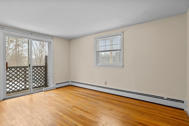 unfurnished room featuring light wood-type flooring, plenty of natural light, and baseboard heating