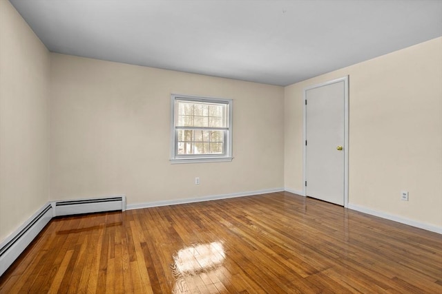 spare room with wood-type flooring and baseboard heating