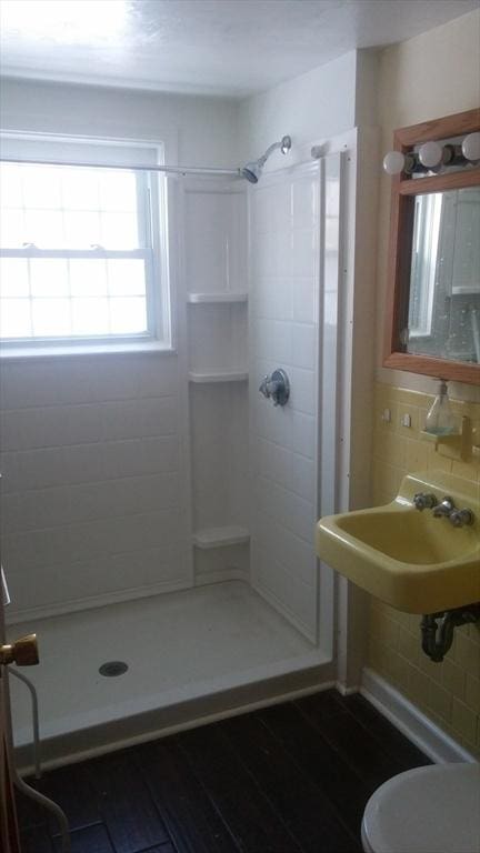 bathroom with walk in shower, sink, tasteful backsplash, and hardwood / wood-style flooring