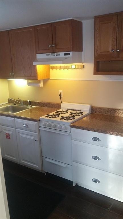 kitchen with white gas range, sink, and white cabinets