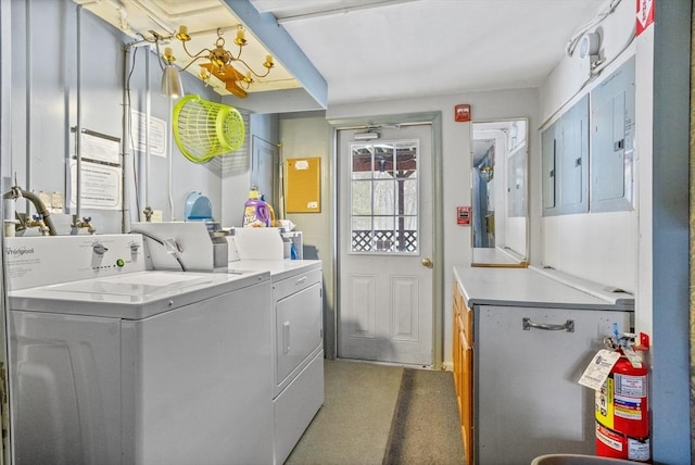 clothes washing area with separate washer and dryer and cabinets