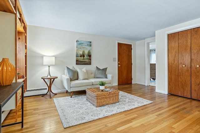 living room featuring a baseboard radiator and light hardwood / wood-style floors