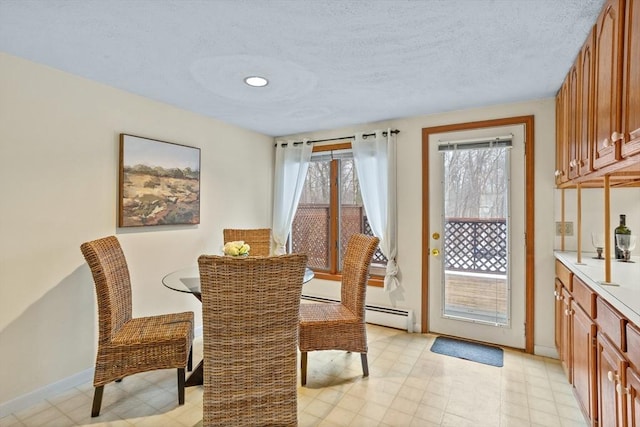 dining area with a baseboard radiator and a textured ceiling