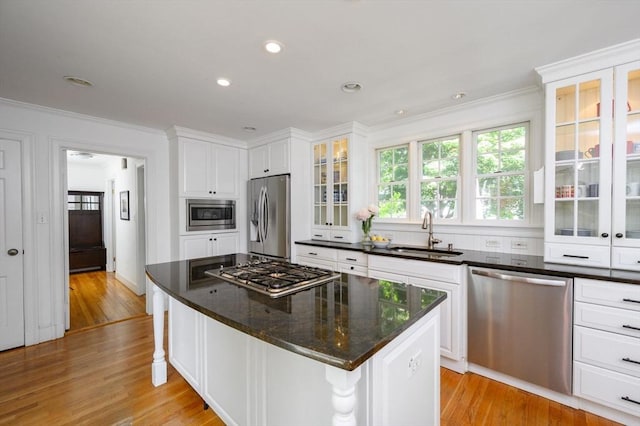51 Rustlewood Rd, Milton, MA 02186 - kitchen featuring appliances with stainless steel finishes, a sink, crown molding, light wood finished floors, and white cabinets
