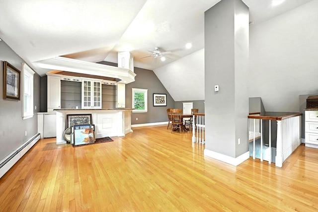 1095 Main St, Hanover, MA 02339 - living room featuring a baseboard heating unit, light wood finished floors, a ceiling fan, bar, and vaulted ceiling