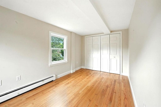 1095 Main St, Hanover, MA 02339 - unfurnished bedroom featuring a baseboard heating unit, light wood-style flooring, and a closet