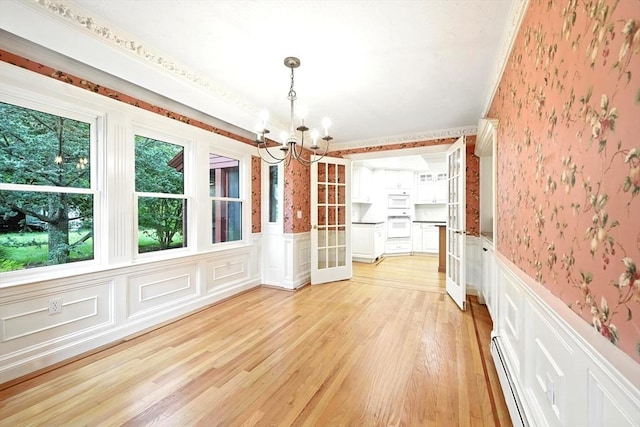1095 Main St, Hanover, MA 02339 - unfurnished dining area with wallpapered walls, a chandelier, wainscoting, a decorative wall, and light wood finished floors