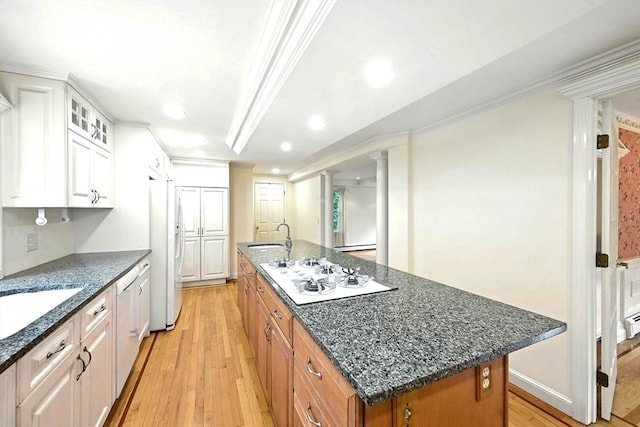 1095 Main St, Hanover, MA 02339 - kitchen with white appliances, a center island with sink, light wood-style flooring, glass insert cabinets, and dark stone counters