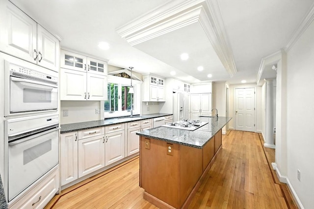 1095 Main St, Hanover, MA 02339 - kitchen featuring white appliances, recessed lighting, crown molding, white cabinetry, and a center island with sink