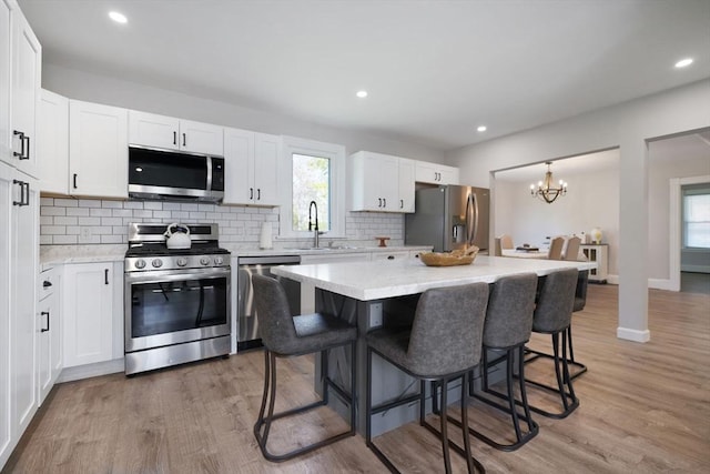 365 Middle Rd, Acushnet, MA 02743 - kitchen with a breakfast bar, white cabinets, tasteful backsplash, a sink, and stainless steel appliances