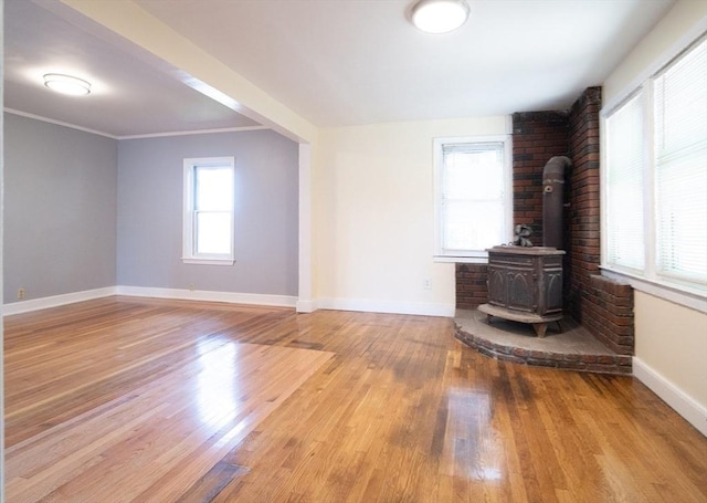 73 Sladen St, Dracut, MA 01826 - unfurnished living room featuring a wood stove and wood finished floors