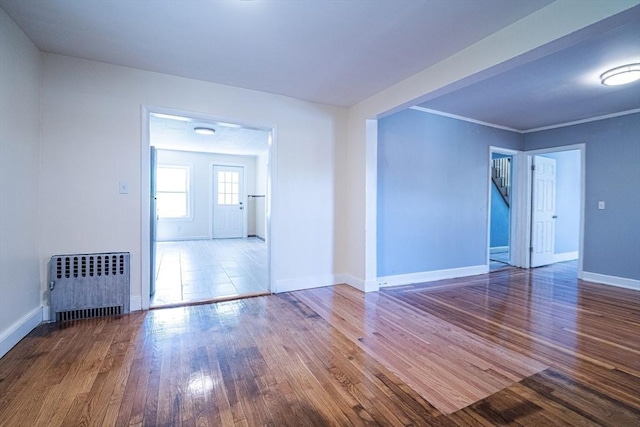 73 Sladen St, Dracut, MA 01826 - unfurnished living room with radiator heating unit, wood finished floors, and crown molding