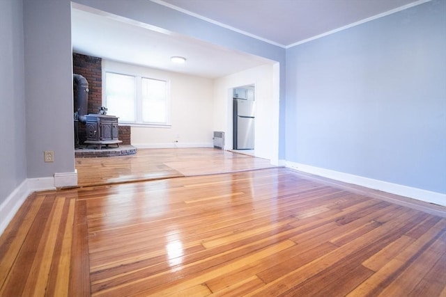 73 Sladen St, Dracut, MA 01826 - unfurnished living room featuring a wood stove, hardwood / wood-style flooring, and crown molding