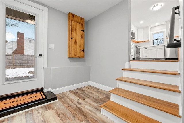 staircase featuring a healthy amount of sunlight and hardwood / wood-style floors