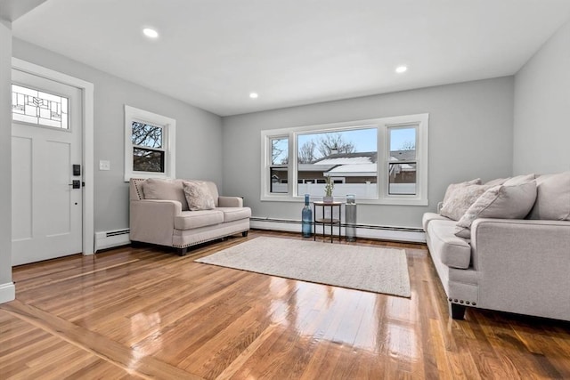 living room featuring baseboard heating and wood-type flooring