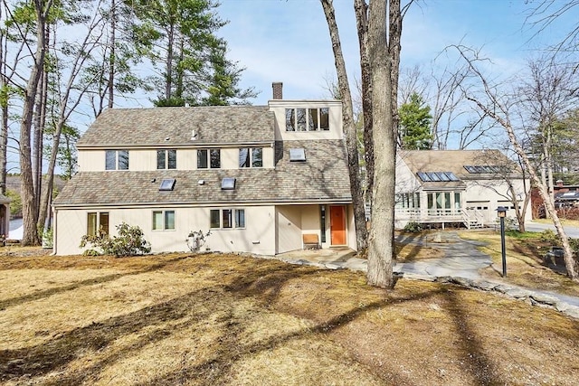 view of front of house featuring a chimney and stucco siding