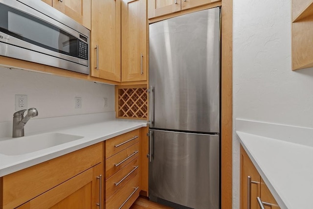 kitchen with light countertops, a sink, and stainless steel appliances