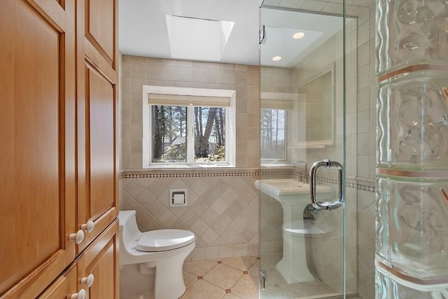 full bathroom with tile walls, toilet, tile patterned floors, recessed lighting, and a stall shower