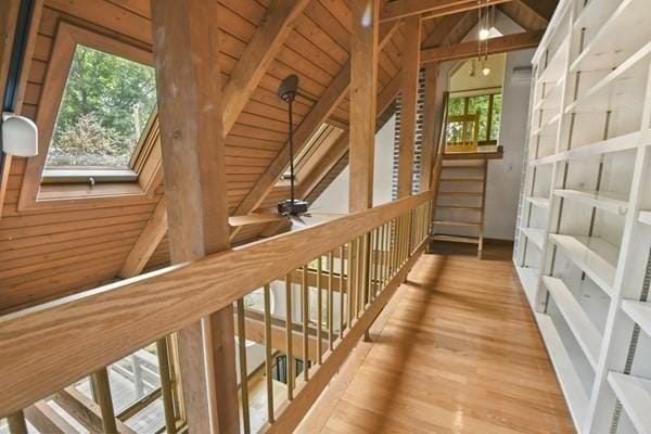 corridor featuring wood finished floors, wood ceiling, and a healthy amount of sunlight