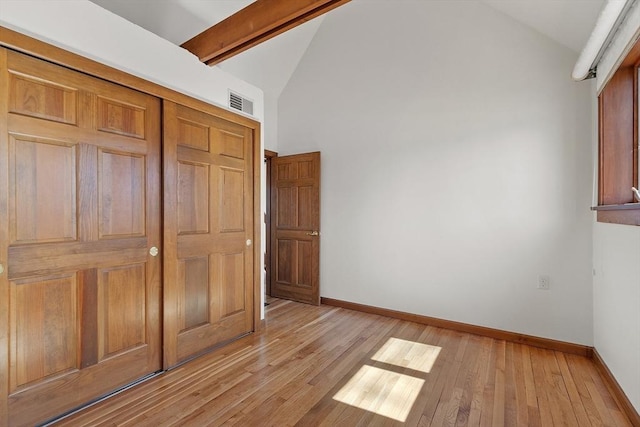 unfurnished bedroom with light wood-type flooring, baseboards, beamed ceiling, and visible vents