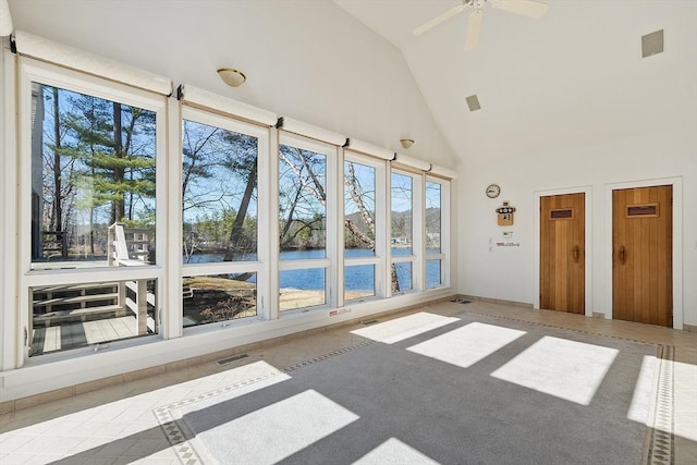 unfurnished sunroom featuring visible vents, high vaulted ceiling, and a water view