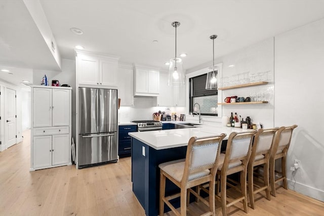 331 Chelsea St Unit 1, Boston, MA 02128 - kitchen featuring appliances with stainless steel finishes, a sink, a kitchen bar, a peninsula, and light wood-style floors