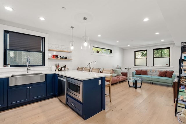 331 Chelsea St Unit 1, Boston, MA 02128 - kitchen featuring a sink, blue cabinetry, a kitchen bar, appliances with stainless steel finishes, and a peninsula