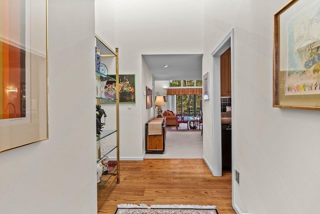 corridor with wood finished floors and baseboards