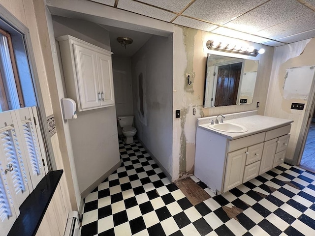 bathroom featuring a paneled ceiling, vanity, toilet, and tile patterned floors