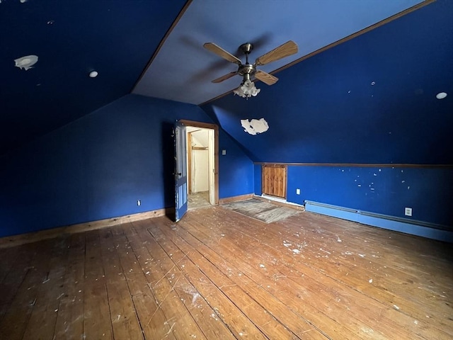 bonus room with wood-type flooring, a baseboard heating unit, a ceiling fan, vaulted ceiling, and baseboards