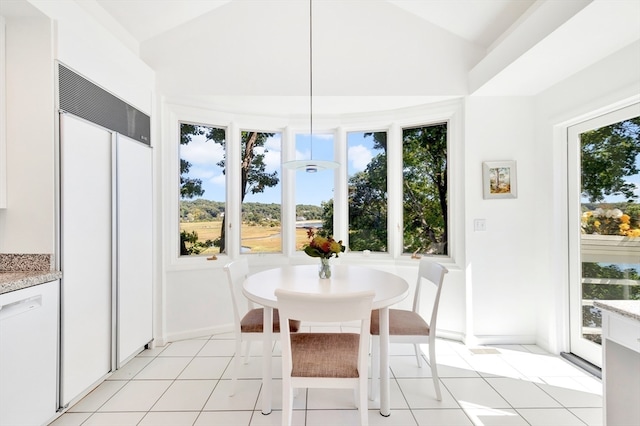 tiled dining area featuring a wealth of natural light and lofted ceiling