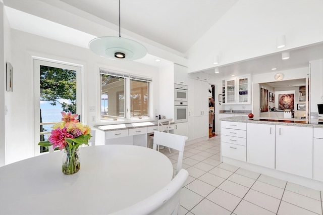 tiled dining space with vaulted ceiling