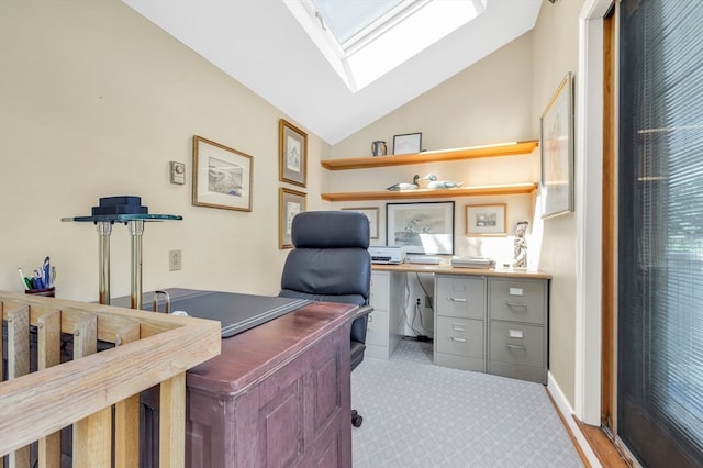 office area with vaulted ceiling with skylight and light colored carpet