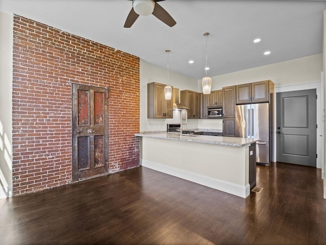 kitchen featuring wall chimney exhaust hood, stainless steel appliances, a peninsula, dark wood-style floors, and ceiling fan