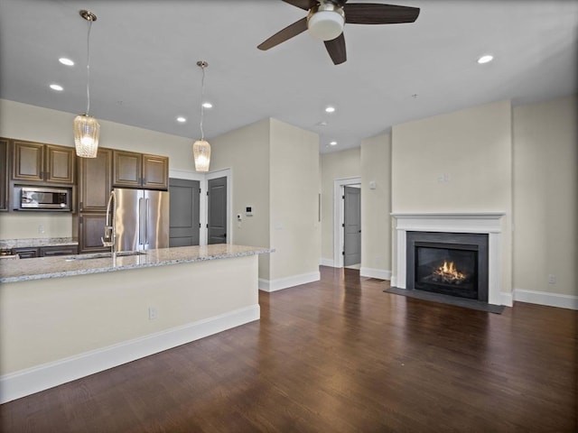 unfurnished living room featuring a fireplace with flush hearth, dark wood-style floors, a sink, recessed lighting, and a ceiling fan