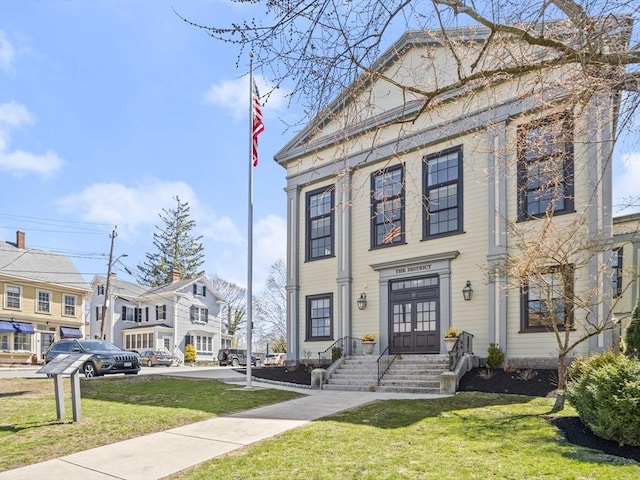 neoclassical home featuring a front lawn, a residential view, and french doors