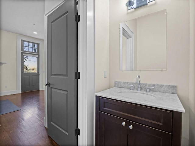 bathroom featuring recessed lighting, wood finished floors, vanity, and baseboards
