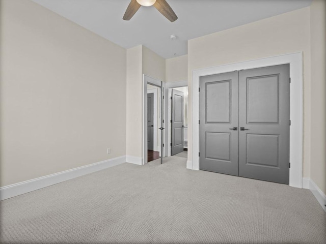 unfurnished bedroom with baseboards, a ceiling fan, carpet flooring, and a closet
