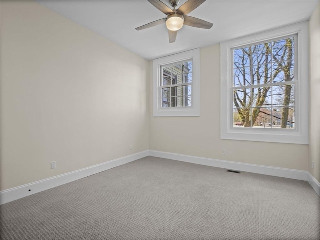 spare room with visible vents, baseboards, carpet floors, and ceiling fan